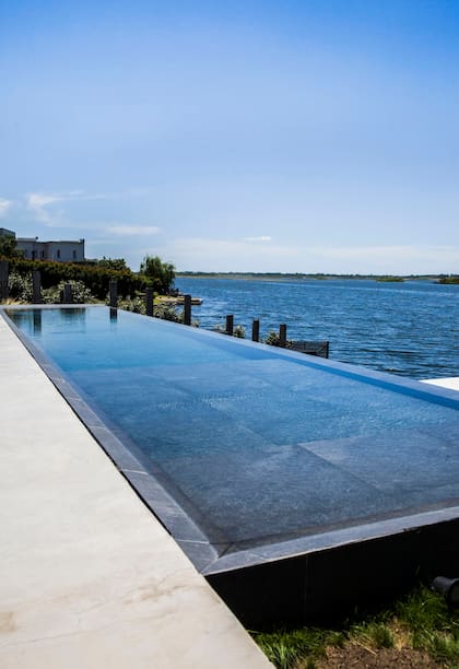 Catorce metros de infinito que encuentra en el negro su efecto profundidad y se funde con el lago en esta casa en Escobar
