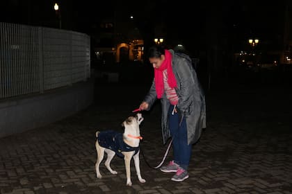 Cecilia le ofrece un "dulce" a su cachorro antes de ir a dormir en una esquina de Recoleta