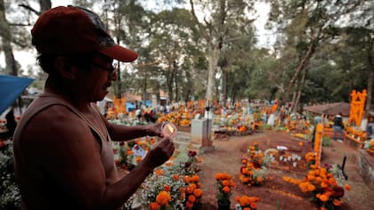 Un hombre prende velas en un cementerio de Tzintzuntzan