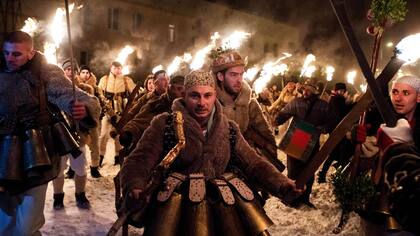 Celebración en el pueblo de Batanovtsi, los habitantes visten diversos atuendos de piel y levantan antorchas