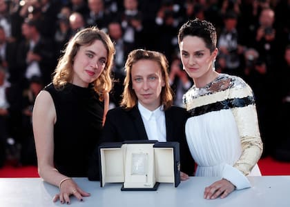 Celine Sciamma posa con su premio al mejor guion, junto a las actrices Adèle Haenel y Noemie Merlant luego de la ceremonia de premiación en Cannes, el 25 de mayo de 2019.
