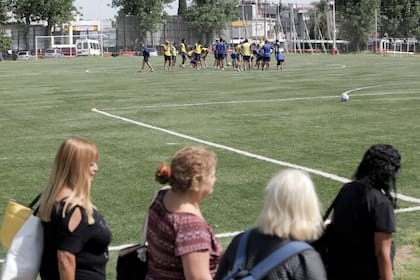 Los jugadores se entrenan en una cancha sintética mientras un grupo de jubiladas se prepara para disfrutar de un día soleado en la pileta del club