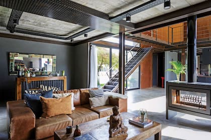 Cerca de la salamandra, el complemento ideal: sofá de cuero color habano y mesa baja de madera para no alejarse del calor.