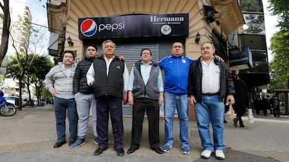 Un grupo de empleados del restaurante, hoy al mediodía, frente al local cerrado a la espera de novedades