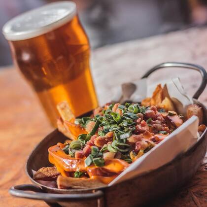 Cerveza artesanal y papas con cheddar, verdeo y panceta, ¿qué más pedir?