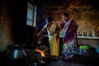 Chain Sahu (der.) prepara una comida para trabajadores de su escuela en Bhanpuri, India