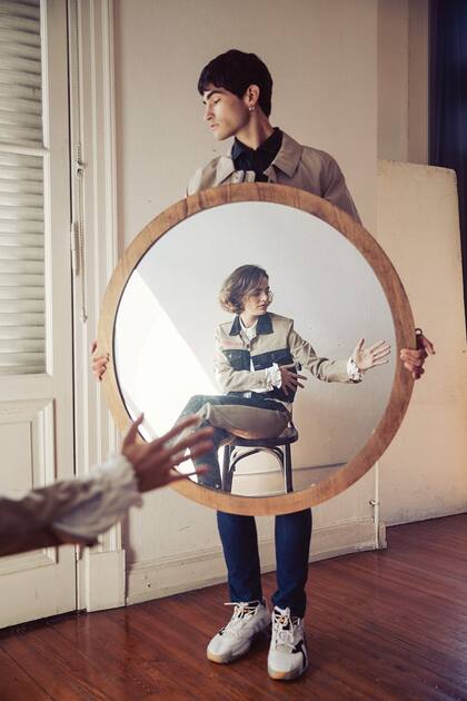 Chaqueta denim con apliques bordados, camisa con volados en los puños y pantalón con tira lateral (Jazmín Chebar). Él, suéter y campera (Perramus), pantalón (Levis) y zapatillas (Adidas)