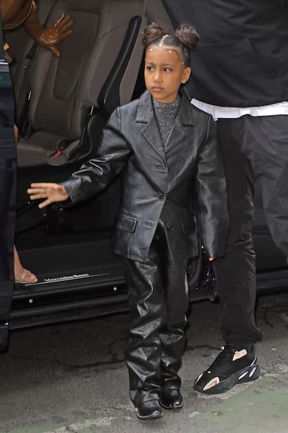 Chaqueta y pantalones de cuero ligeramente oversize y remera de lurex para ver cantar a su papá en París. El pelo, cuidadosamente recogido en dos rodetes altos, está decorado con pequeños cristales.