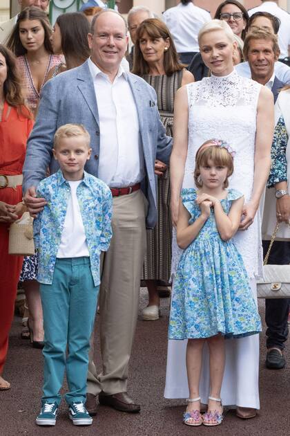 Charlene eligió un look total white compuesto por una túnica larga de encaje sin mangas y pantalones anchos diseñados por Terrence Bray. Gabriella llevó un vestido azul de flores en composé con la camisa de su hermano.