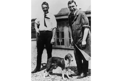 Charles Best (izq) y Frederick Banting (der) con uno de los perros del laboratorio