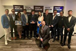 Charles Hoskinson, en cuclillas, delante de Javier Milei, en el encuentro Forum Tech; el empresario estadounidense dijo que le pidieron dinero a cambio de pactarle un encuentro con el Presidente; en los extremos de la imagen, los organizadores del evento: Terranos Godoy (a la izquierda) y Mauricio Novelli (a la derecha)