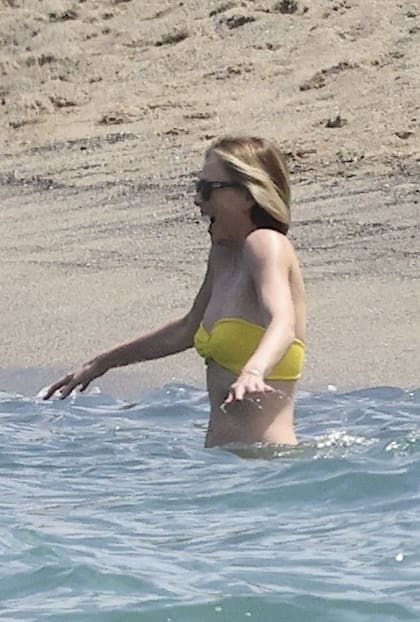Charlize Theron fue vista en una playa de Hawái. La actriz lució un bikini amarillo sin breteles y gafas negras para protegerse del sol. En la imágen, se la ve entrando al mar muy lentamente para aclimatarse al cambio de temperatura