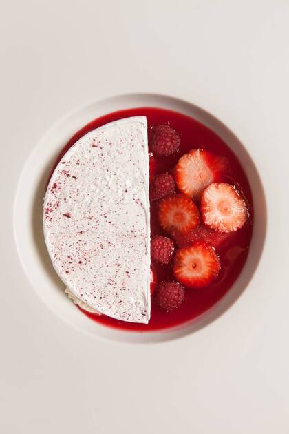 Cheese cake de requesón con consomé de frutillas y frambuesas con granito de frutos rojos.