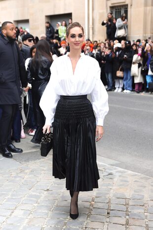 Chiara Ferragni optó por una camisa de mangas abullonadas y falda midi plisada. Completó su look con una cartera Lady Dior.