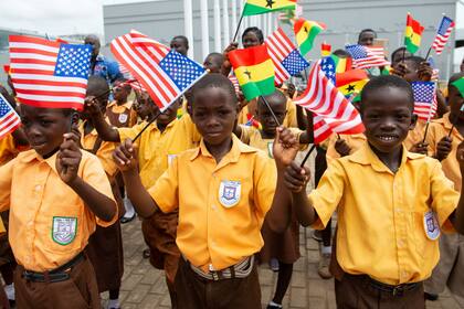 Chicos de Ghana con banderas estadounidenses reciben a Melania Trump en el aeropuerto