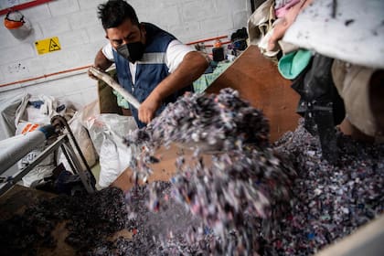 Un hombre trabaja en una fábrica que recicla ropa usada desechada en el desierto de Atacama