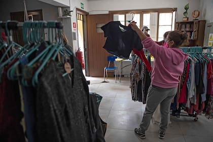 Una mujer compra ropa usada en la fábrica de hilados ecológicos Ecotex