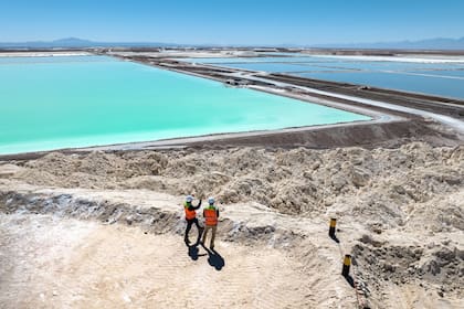 En esta vista aérea, los visitantes se paran sobre un gran montículo de subproducto de sal de la producción de litio en una mina en el desierto de Atacama el 24 de agosto de 2022 en Salar de Atacama, Chile