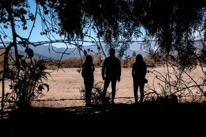 Un grupo de personas observa el embalse seco de Collahue