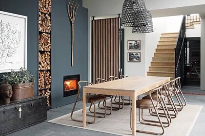 Chimenea (Charnwood). Mesa ‘Harris’ (James Mudge). Sillas de acero tubular con asiento tapizado en cuero (Studio 19). Lámparas colgantes (Loft Living).