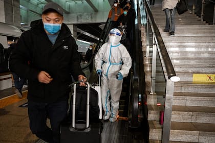 Un pasajero con equipo de protección en una estación de tren en Pekín el 28 de diciembre de 2022