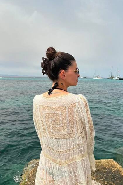 China Suárez posó de espaldas al mar con una bikini negra y un kimono blanco con detalles bordados.