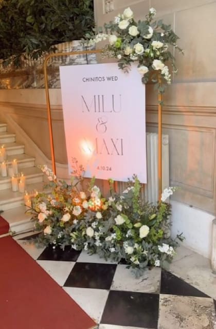"Chinitos wed", el cartel de bienvenida decorado con rosas blancas, presentes en toda la ambientación de la fiesta.