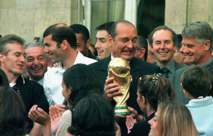 Jacques Chirac, entonces Presidente francés, con la Copa en su poder en 1998, rodeado por Deschamps, Zidane, el DT Aimé Jacquet en los jardines del Palacio del Elíseo... y justo detrás del mandatario, Pirès