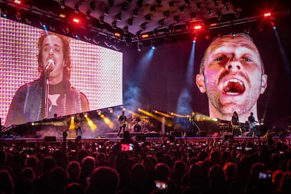 Chris Martin en las pantallas junto a Gustavo Cerati. El líder de Coldplay participó de la versión de "De música ligera" que suena en la gira. Fue el último tema de la noche