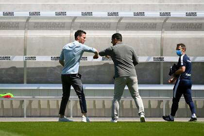 Christian Eichner, entrenador del KSC, a la izquierda y Dimitrios Grammozis, entrenador del Darmstadt 98, se saludan por el codo durante el segundo partido de fútbol de la Bundesliga 2 entre Karlsruher SC y SV Darmstadt 98,