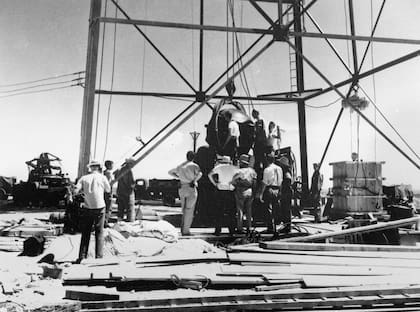 Científicos y empleados trabajan para elevar la primera bomba atómica en el marco del Manhattan Project