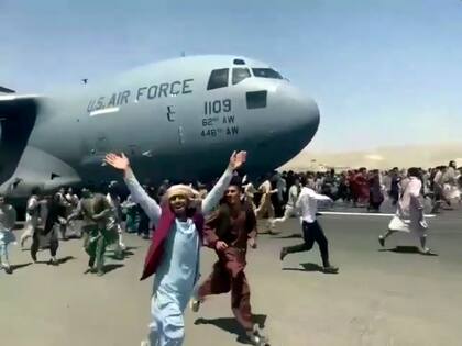 Cientos de personas corren tratando de treparse al avión militar estadounidense que despegaba de Kabul