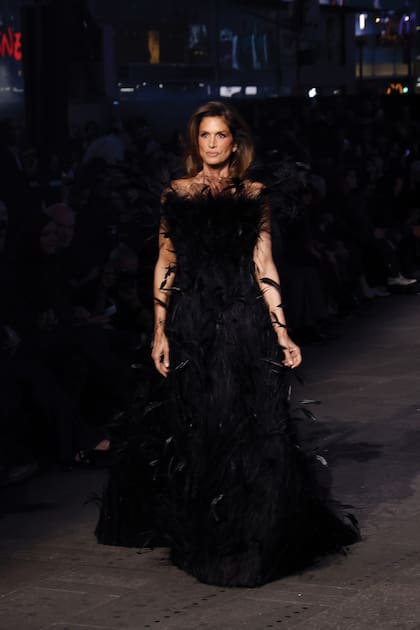 Cindy Crawford impactó con un strapless negro, de falda amplia, cubierto de plumas y lideró la lista de caras conocidas en el desfile