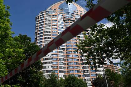 Cinta policial bloquea una zona fuera de un edificio de apartamentos de varios pisos después de un ataque con drones reportado en Moscú el 30 de mayo de 2023.