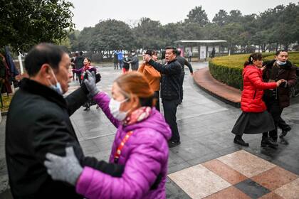 Adultos bailando en Wuhan a un año del inicio de la pandemia. El panorama ya no es apocalíptico.