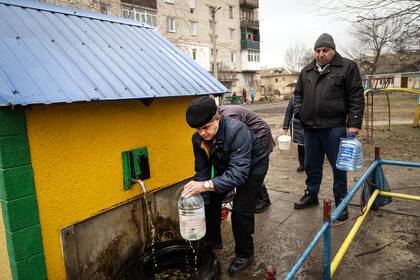 Ciudadanos de Schastia, en el este de Ucrania, recolectan agua tras un corte de energía (Lynsey Addario/The New York Times)
