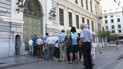 Ciudadanos griegos hacen fila frente a un banco en julio de 2015 para retirar fondos durante una crisis bancaria