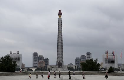 Ciudadanos norcoreanos parecen pequeños en comparación con la Torre Ju Che en la Plaza Kim Il Sung el 21 de julio de 2013, en el centro de Pyongyang, Corea del Norte.