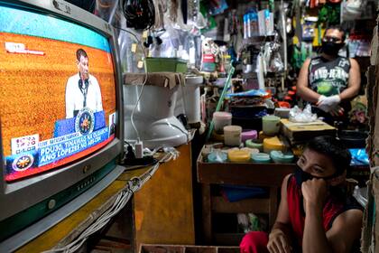 Ciudadanos observan al presidente de Filipinas, Rodrigo Duterte, ayer durante su mensaje en la Cámara de los Representantes
