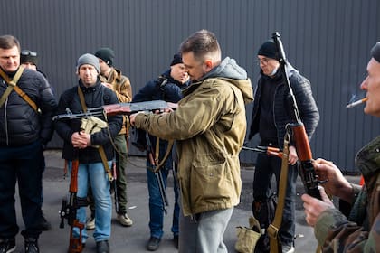 Civiles miembros de una unidad de defensa territorial preparan sus armas para combatir en Kiev, el 26 de febrero de 2022