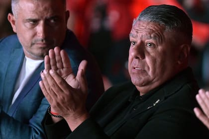 Claudio "Chiqui" Tapia aplaude durante el evento de presentación del trofeo de la Copa del Mundo en La Rural; a su lado, Luciano Nakis