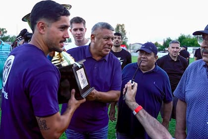 Claudio Chiqui Tapia entrega el trofeo al capitán Kevin Dubini, de Acassuso, que ascendió a la Primera Nacional; el vicepresidente Francisco Pipo Marín (de gorra) observa