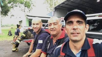 Claudio Dziesko (izq.) y dos amigos del cuartel de Bomberos Voluntarios de Hurlingham, a quienes considera parte de su familia