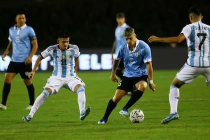 Claudio Echeverri (izquierda), en función defensiva; en el clásico con Uruguay el atacante no repitió el brillo de otras actuaciones.