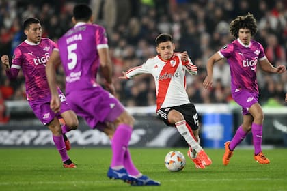 Claudio Echeverri, rodeado, en un partido copero frente a Libertad