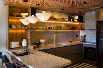 Gran protagonista de la cocina es el empapelado de Tienda Wallpaper en el techo. Los muebles fueron realizados en melamina 'Scotch' (Faplac) y Rauvisio Noir 'Trench Coat' (Rehau). El impresionante granito es 'Blanco Dallas' (De Stefano).