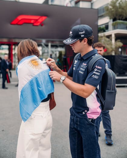 Colapinto firma la bandera de una fan antes de afrontar la primera práctica libre en Bakú