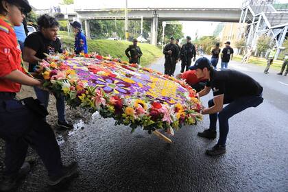 Colocación de uno de los arreglos florales, en la previa del desfile de la Feria de las Flores