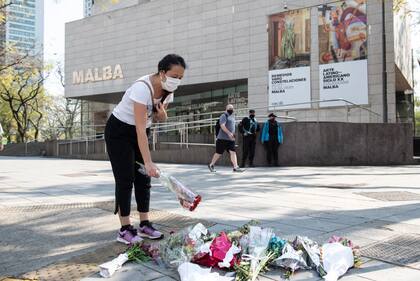 Una mujer deja unas rosas en el lugar donde fue asesinado el policía