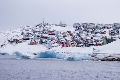 Coloridas viviendas cubiertas de nieve vistas desde el mar en Nuuk, Groenlandia